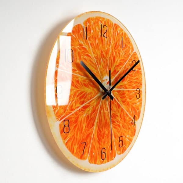 Horloge avec une image de coupe d'orange dont on voit la pulpe , installée sur un mur blanc