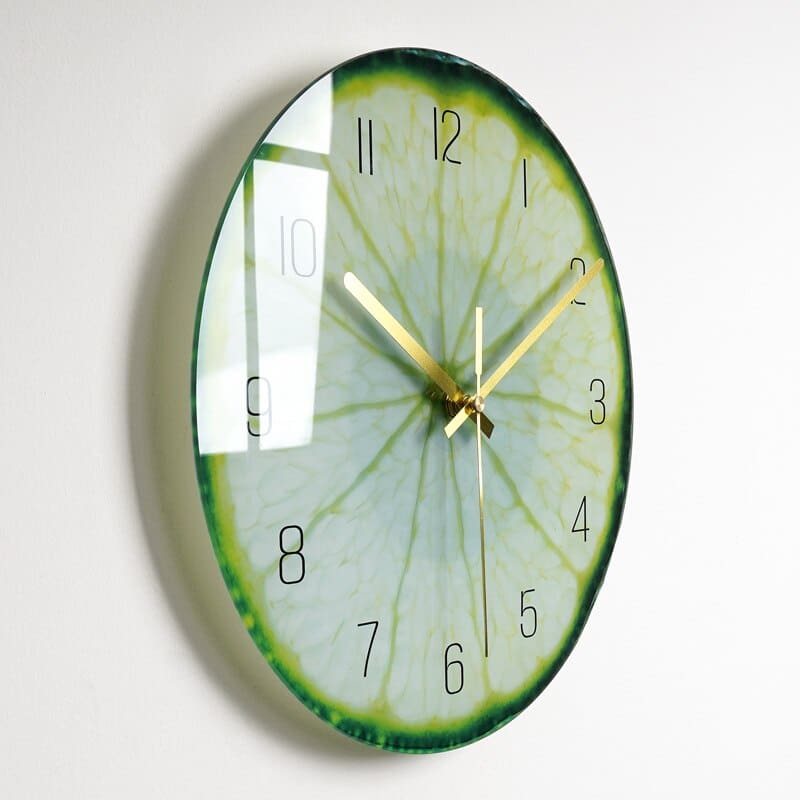 Horloge avec une image de coupe de citron vert dont on voit la pulpe , installée sur un mur blanc