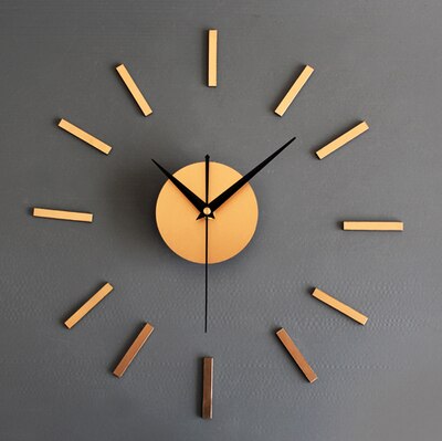 Horloge dorée sans chiffre, avec aiguilles noire, de style scandinave et sans cadre, elle est installée sur un fond gris foncé
