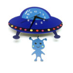 Horloge murale pour enfant en forme de vaisseau spatial, un petit alien fait office de coucou , le cadran à aiguilles se trouve sur le vaisseau qui est bleu