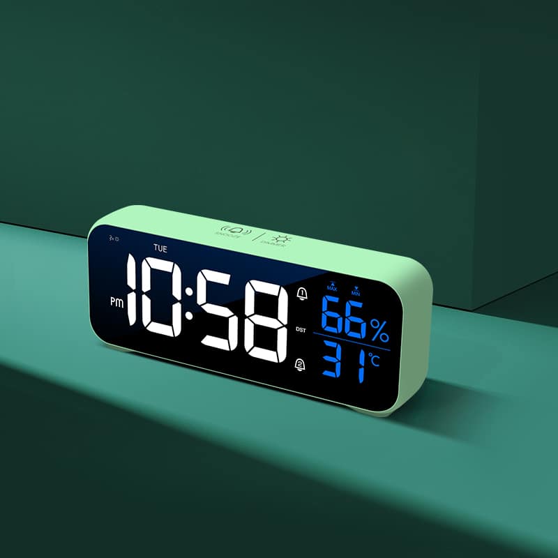 réveil à affichage led digital et commande vocale de couleur verte, posé sur un support vert
