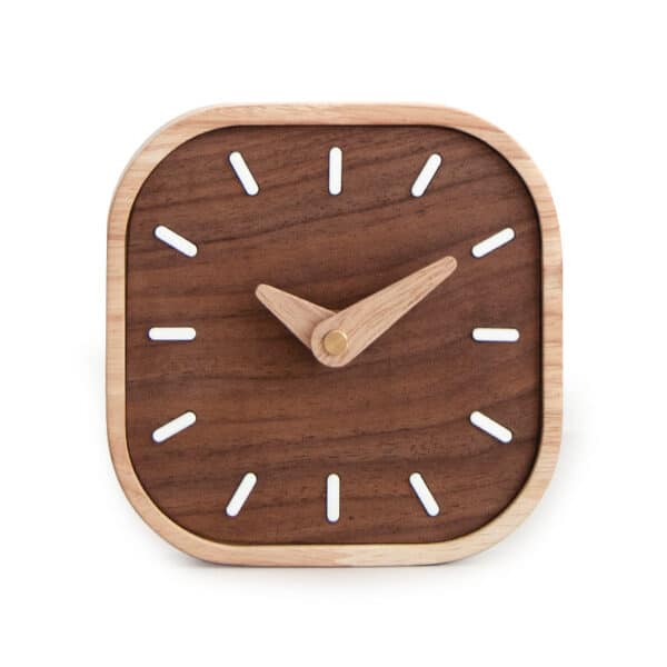 Horloge de bureau minimaliste en bois foisé avec les contours clairs, carrée avec les angles arrondi, présentée sur fond blanc