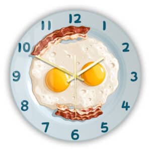 Horloge murale de cuisine avec motif Œufs au plat et bacon présentée sur fond blanc