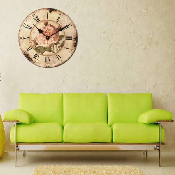 Horloge murale ronde hortensia peint accroché à un mur, en dessous un canapé vert.