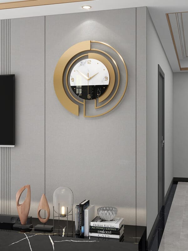 Horloge murale moderne et design, avec cadran blanc et noir nordique et 3 aiguilles, fabriqué en métal, armature de couleur or, forme ronde, située dans une pièce à vivre au-dessus d'une table