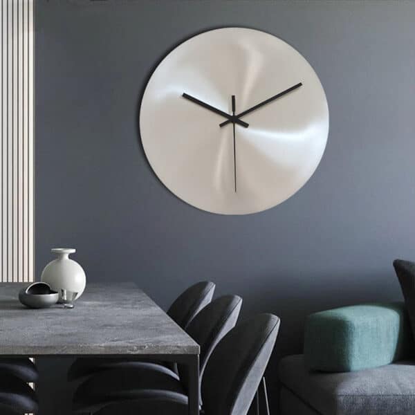 Horloge murale originale argentée de style industriel minimaliste moderne installée au-dessus d'une table à manger