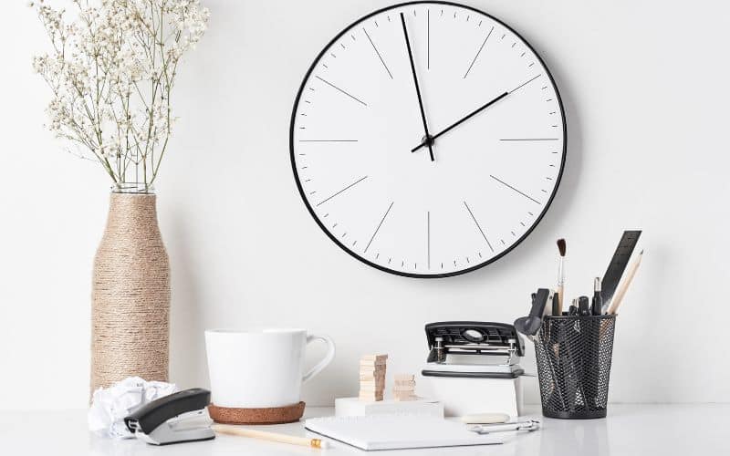 horloge murale au dessus d'éléments décoratifs dans les tons blancs