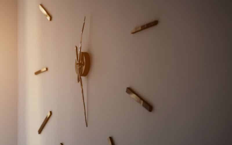 Horloge minimaliste collée au mur, le cœur central avec les aiguilles, puis autour des barres pour définir les heures.