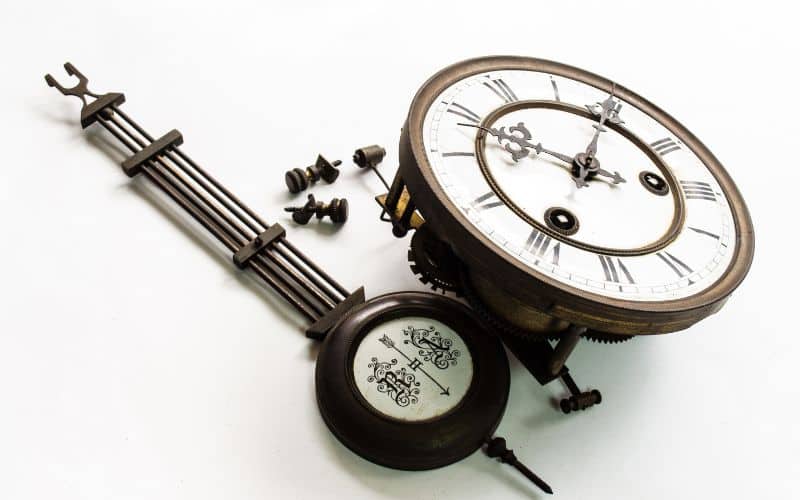 Horloge pendule démontée, il n'y a que le pendule et le cadran de l'horloge.