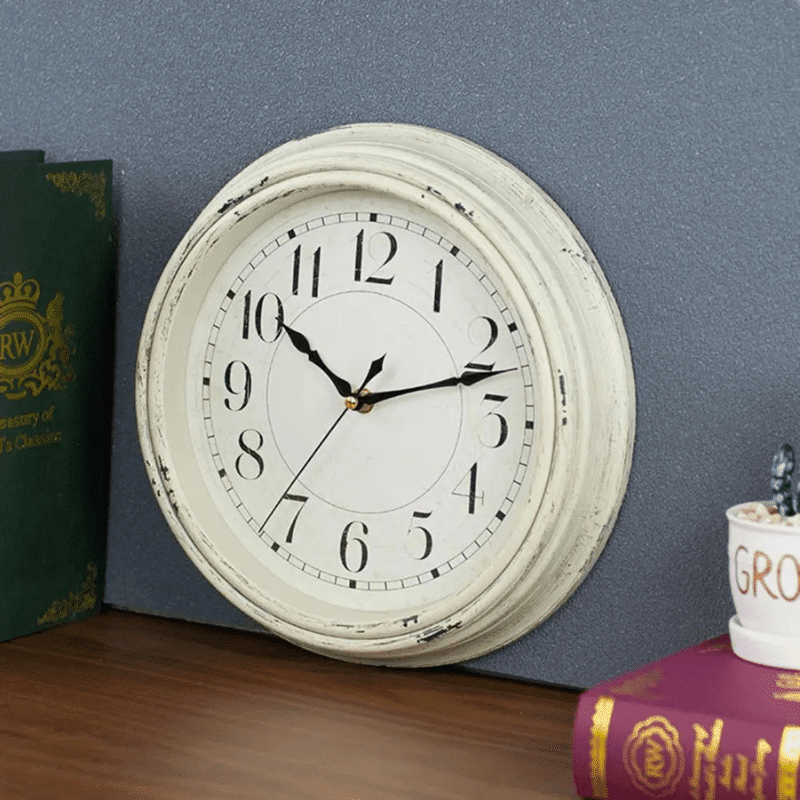horloge murale ronde vintage silencieuse élégante blanche sur fond gris et sur table en bois
