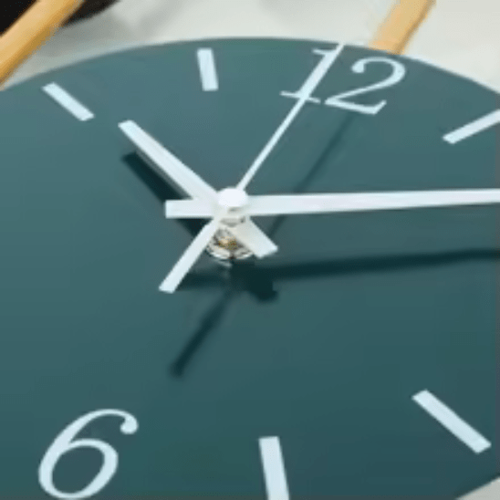 horloge design murale decorative en metal dore zoom sur le cadran, chiffres et aiguilles blancs