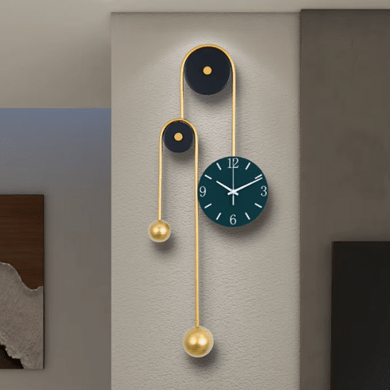 horloge design murale decorative en metal dore sur un mur central. On voit un cadre à gauche sur le mur du fond